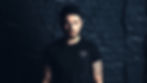 Tattooed man in black streetwear t-shirt, urban backdrop