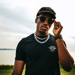 Male model wearing the REALLY COOL® SIGNAL Collection MX Signature Series 420 GSM heavyweight cotton black t-shirt by the water at sunset.