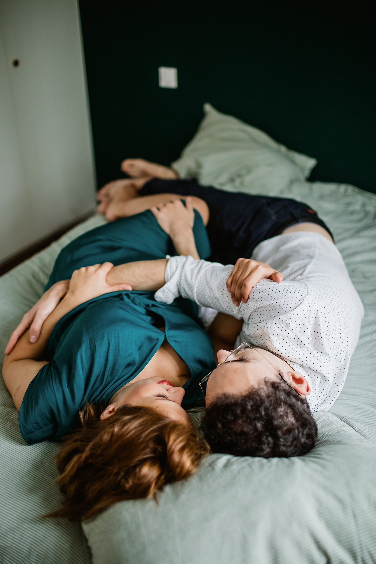 couple allongé dans leur lit la femme est enceinte