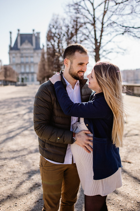 un couple enlacé aux Tuileries Paris la femme est enceinte