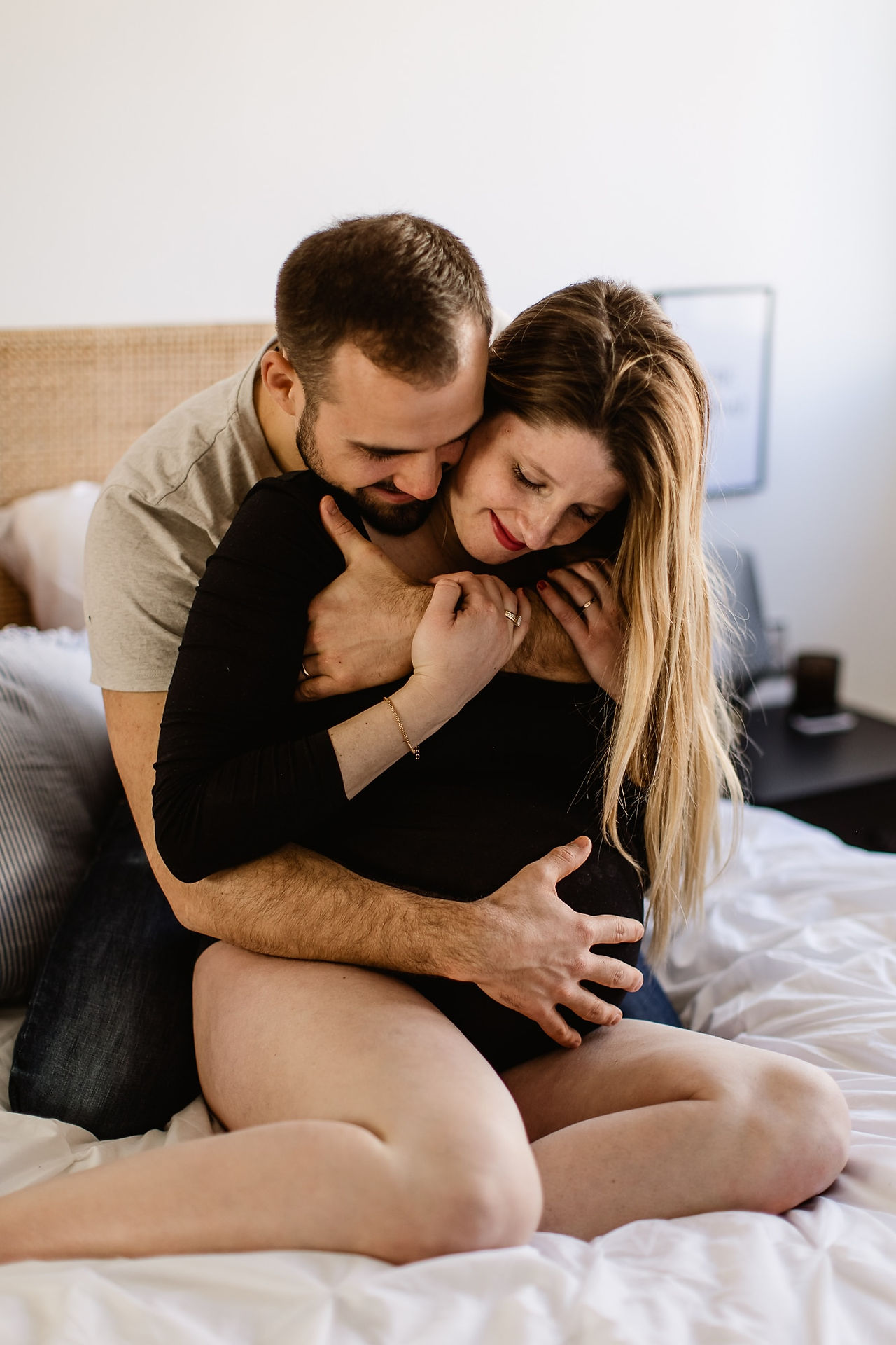 un couple enlacé chez eux la femme est enceinte