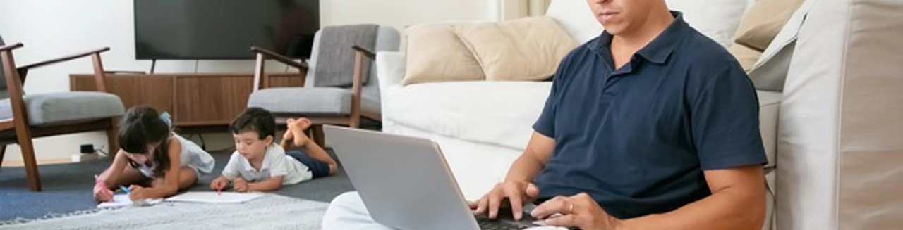 focused-dad-working-home-sitting-floor-using-computer-while-his-little-kids-drawing74855-8