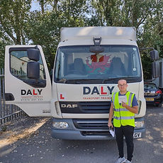 A driver standing in front of a trailer
