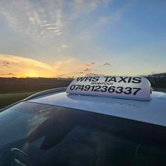 A car with a taxi sign on top of it