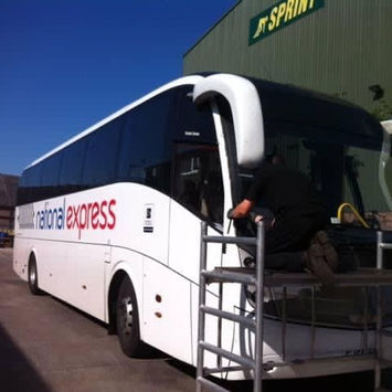 A white bus parked in front of a building