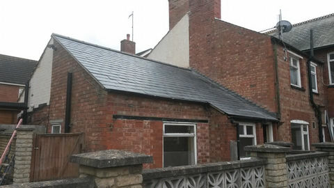 Brick house with chimney and wall.
