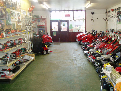 A variety of lawn mowers displayed in a room