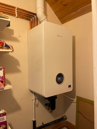A wall-mounted white Worcester boiler installed inside a utility cupboard