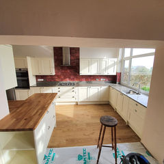 A large kitchen with wooden floors and an island with a wooden counter