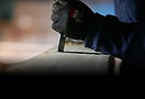Gloved hand chiseling a surface