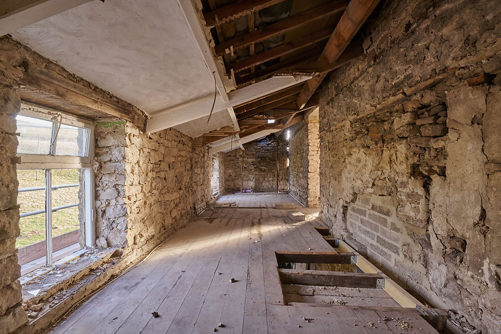 Dilapidated room with stone walls and damaged wood floor