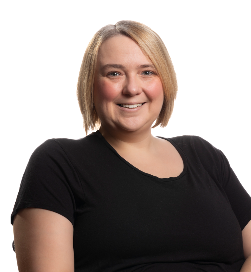 Smiling woman with long dark hair wearing patterned jacket over a black shirt.