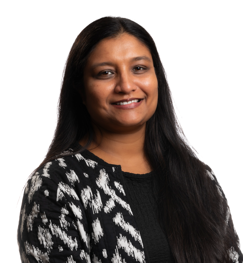 Smiling woman with long dark hair wearing patterned jacket over a black shirt.