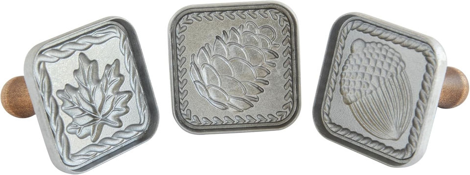 Square metal emblem with pine cone design