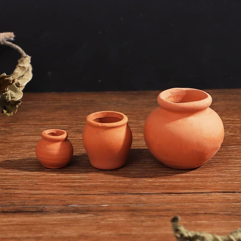 Three terracotta pots of varying sizes on wood