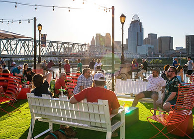 People casually sitting in front of the Cincinnati skyline