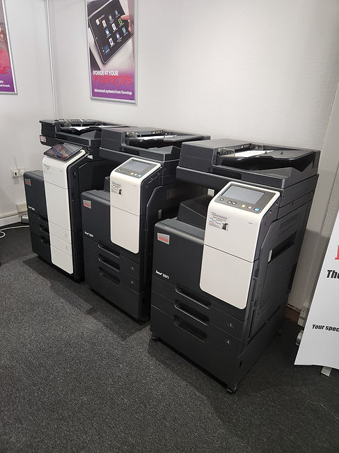 Close-up view of black and white commercial photocopiers with digital touchscreen control panels