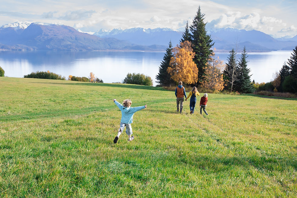 the kilcher family walking in their back yard facing the mountains and water