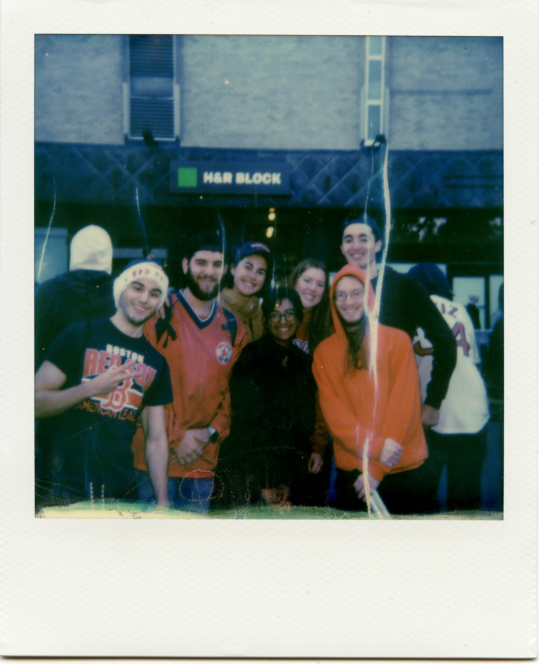 A polaroid of 7 young people in a group smiling