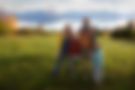 the kilcher family standing on their alaskan homestead with mountians and water in the background