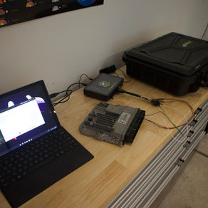 Laptop connected to an ECU tuning device and engine control unit on a workbench at Canterbury Tuning for Stage 1 or Stage 2 tuning upgrades