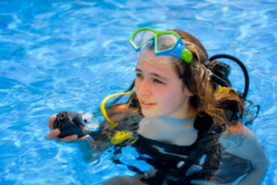 Girl in the pool learning to scuba dive.
