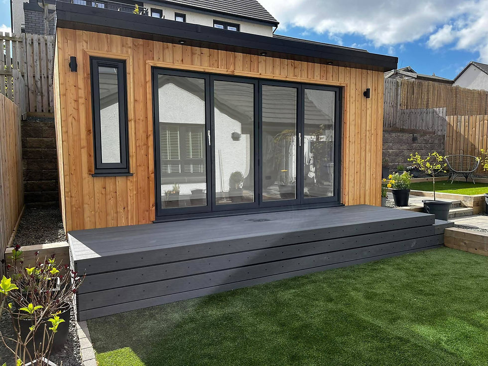 Modern garden office with large windows, wooden exterior, and surrounded by greenery.