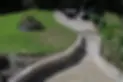 overhead view of raised lawn, garden walling and paving with seating area