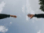 2 hands reaching out across the sky to o