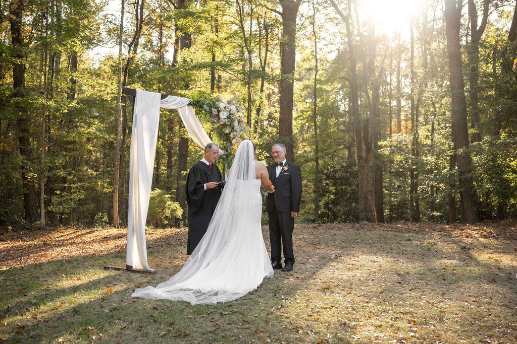 bride and groom at the alter with sun shining through the woods at wedding venue in hamilton, ga, wedding venue near atlanta ga, wedding venue near columbus, ga , wedding venue near lagrange ga, wedding venue near phenix city alabama