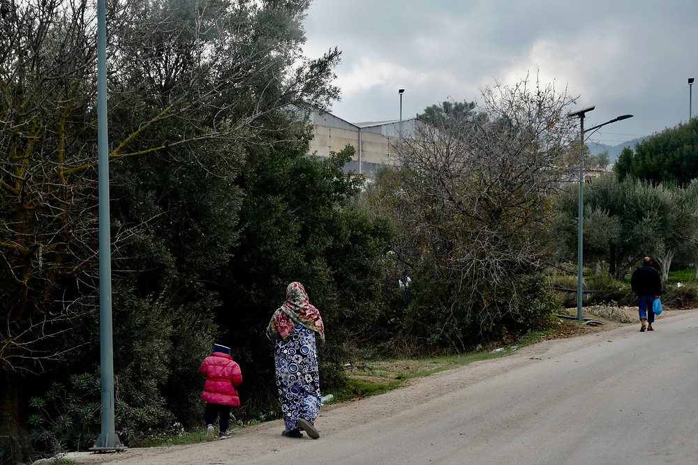 A mother and child walk towards Vial Camp.