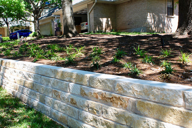 This client came to us because the HOA said he had to do something about the soil in his yard eroding onto the street. Because he had some plumbing done, the yard was completely dug up and there was not much grass left. Additionally, all the plants around the house were old and dated and needed to be replaced. In the end, we came up with a terracing plan that used steel and boulders along with limestone block walls. We then reduced the height of the walls on either side of the entry stairs to make it more inviting. Lighting was added to the entry for night time use. The plantings around the front entry were arranged to try to give as much symmetry as possible to the asymmetrical house.
