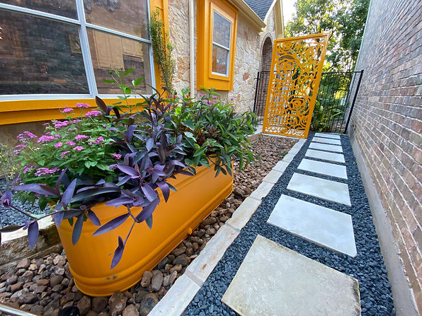This client is the mayor of Sunset Valley. She wanted to accomplish two goals, creating a more useable space in the front yard for her family and dogs to spend time in and preventing town members from knocking on her front door when they have requests. We created a plan with a fence around the front, expanded some bed areas, added a small seating area and incorporated some modern design elements mixed with her love of flair.