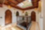 Moroccan heritage hallway with ornate doors and skylight