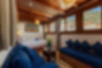 Well-appointed rooms and suites with a bed, blue seating, and mountain views