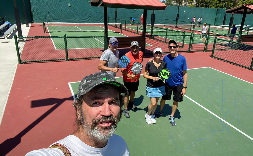 Seven foot man taking photo of pickleball players in Carlsbad, CA