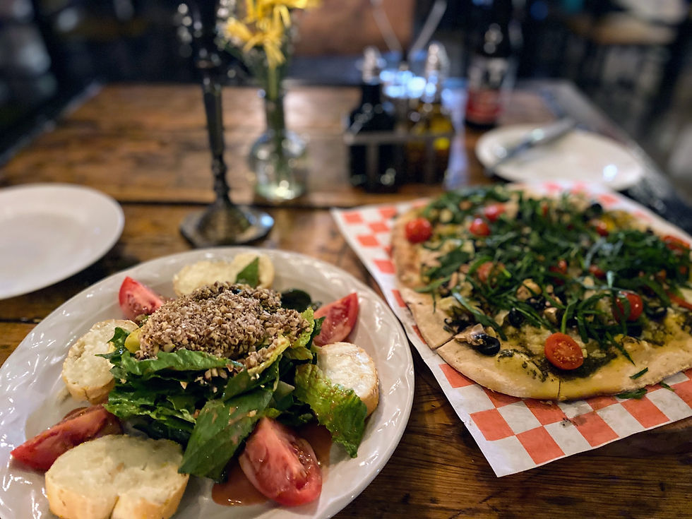Salad with goats cheese tomatoes lettuce nuts and thin vegetarian pizza at Colibri restaurant