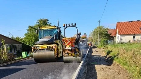 Asphaltierungsarbeiten einer Straße mit zwei gelben Straßenwalzen.