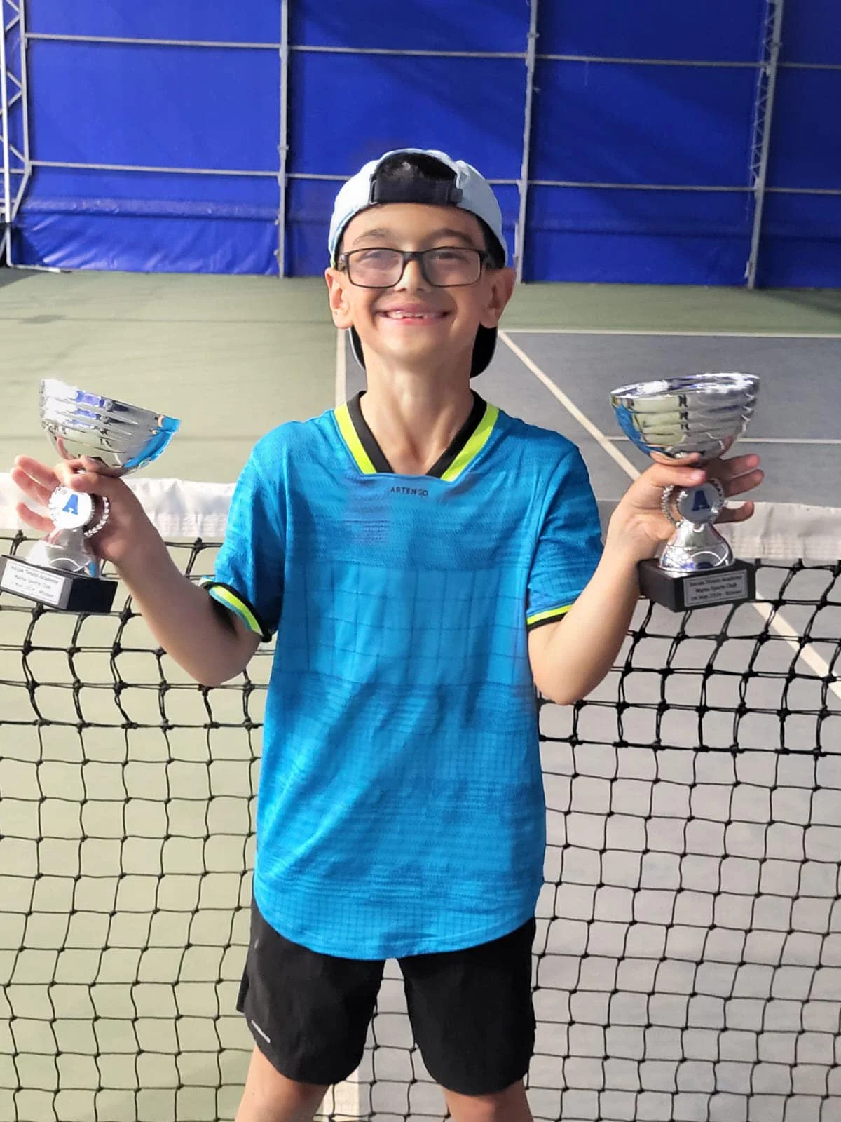 Tennis kid with 2 trophys