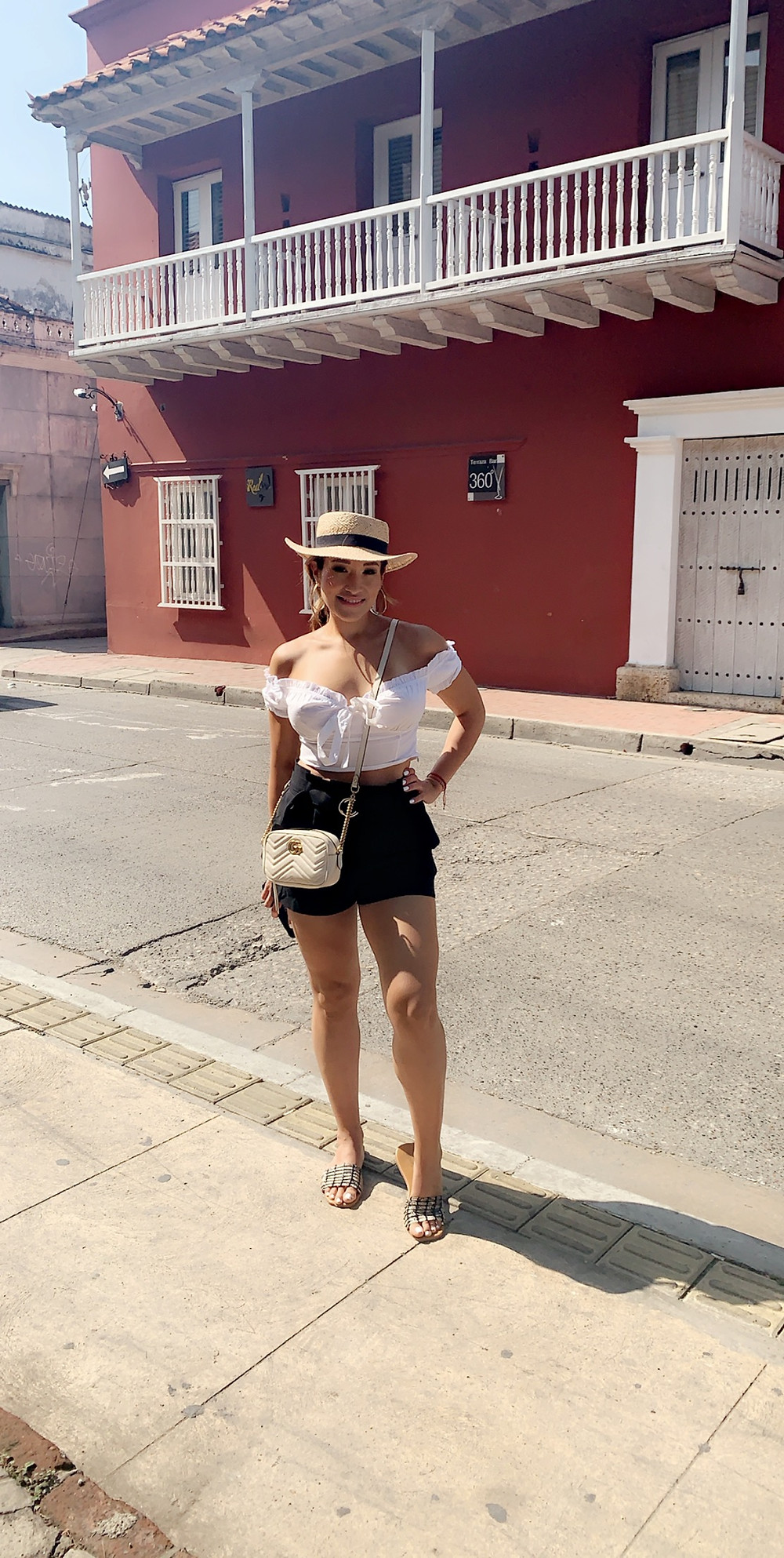 teresa stands outside in a cute hat near a hotel