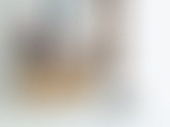 Pracownik w koszuli i krawacie pakuje dokumenty oraz rzeczy osobiste do kartonowego pudełka na biurku, symbolizując zakończenie lub zawieszenie stosunku pracy i spór pracowniczy.