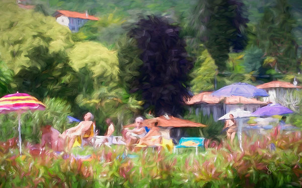 Colorful beach umbrellas and sunbathers along the shore of Lake Como
