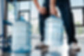 cropped-view-of-delivery-man-holding-heavy-bottle-2024-11-18-06-46-03-utc.jpg