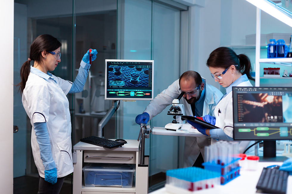 scientist-analyzing-blood-sample-vacutainer-with-researching-team-looking-through-microsco