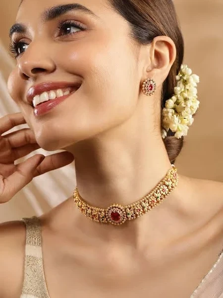 Woman models gold choker necklace and earrings