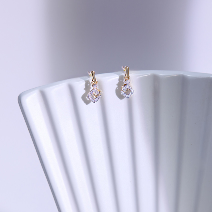 Elegant diamond earrings displayed on white stand