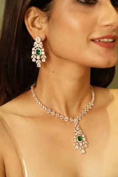 Elegant rose gold necklace and earrings with green emeralds and clear stones