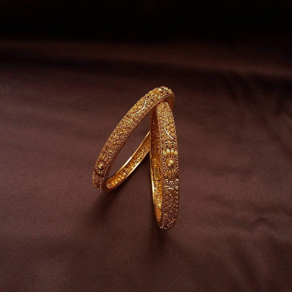 Ornate gold bangles on brown background