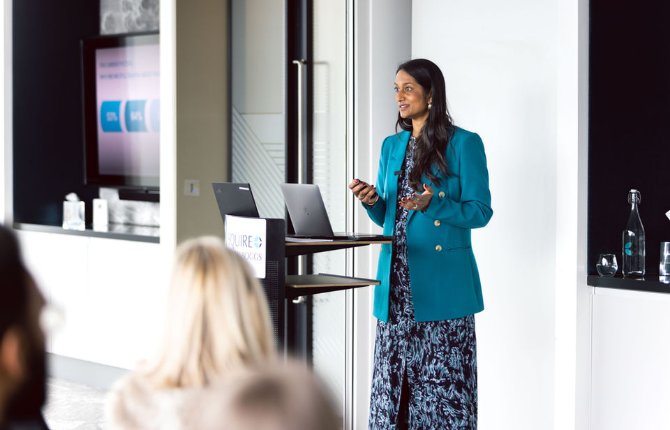 Photograph of a woman in a law firm in Manchester stood behind a lecture delivering a talk on career confidence