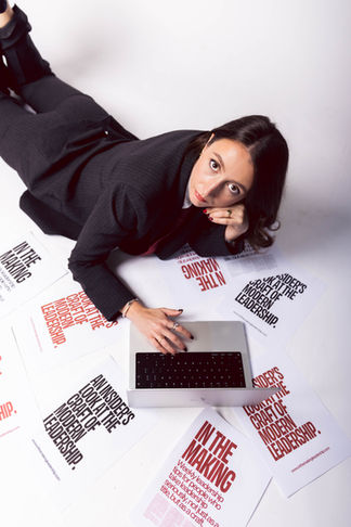 business brand photography of a woman in a suit surrounded by papers and a laptop